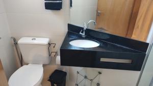 a bathroom with a black sink and a toilet at Lagoa Flats com Super Varanda in Lagoa Santa +8 photos