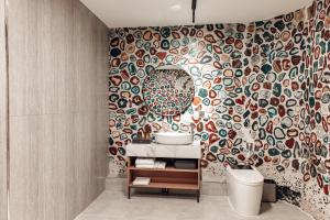 a bathroom with a sink and a mosaic wall at Sansar Hotel Erdenet in Erdenet +56 photos