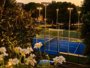 a tennis court with white flowers in front of it at Residence MareVerde in Senigallia
