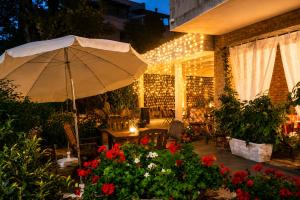 a patio with an umbrella and flowers and lights at Residence MareVerde in Senigallia