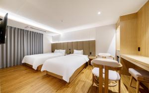 a hotel room with two beds and a television at d hotel in Seoul