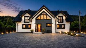 a large white house with a lot of windows at Althea Ustrzyki Apartments in Ustrzyki Dolne