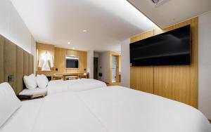a hotel room with a large bed and a flat screen tv at d hotel in Seoul