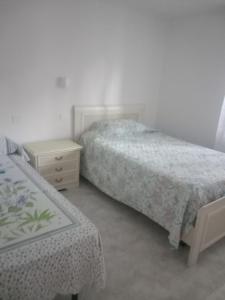 a bedroom with two beds and a nightstand and a bed and a table at Casa vacanze Melania in Cupra Marittima