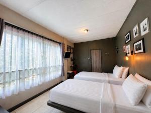 a bedroom with two beds and a window at BB House Rambuttri2 บีบี เฮ้าส์ รามบุตรี2 in Bangkok +15 photos