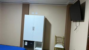 a white refrigerator in a room with a tv at El Refugio del Rey in Cajamarca +1 photo