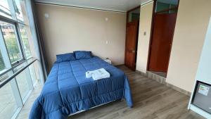 a bedroom with a bed with a blue comforter at El Refugio del Rey in Cajamarca
