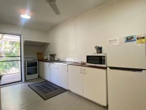 a kitchen with white cabinets and a refrigerator at The Barracks Arcadia 1 in Arcadia +6 photos