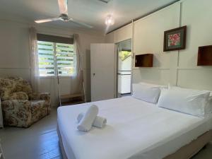 a bedroom with a large white bed and a chair at The Barracks Arcadia 1 in Arcadia