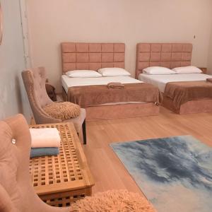 a room with two beds and a chair and a rug at Sekebun Bunga in Tumpat