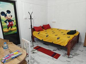 a room with a mickey mouse bedroom with a bed at Heinrich Wolfi Private Cotege in Pattiyūrgrāmam