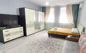 a bedroom with a bed and a tv and a couch at ЖК Куралай in Qyzylorda +1 photo