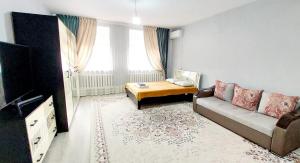 a living room with a couch and a tv at ЖК Куралай in Qyzylorda