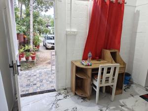 a small desk with a chair and a red curtain at Heinrich Wolfi Private Cotege in Pattiyūrgrāmam +16 photos