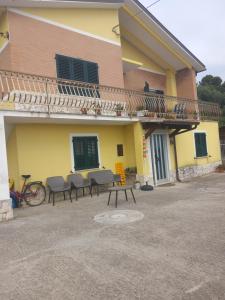 a building with a table and chairs in front of it at Casa vacanze Melania in Cupra Marittima