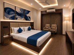 a hotel room with a bed and two chairs at Sapphire Hotel & Convention Centre in Baddi
