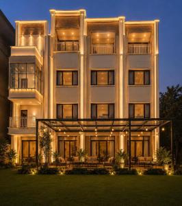 a large white building with a lawn in front of it at Sapphire Hotel & Convention Centre in Baddi
