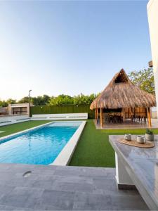 a villa with a swimming pool and a hut at Guantalamera Resort in Tubará