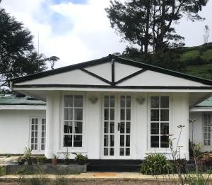 a white house with a black roof at Fair Field Bungalow in Nuwara Eliya