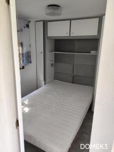 a bedroom with a white bed in a room at Gospodarstwo Agroturystyczne RYBAKÓWKA in Warlubie