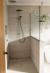 a bathroom with a shower with a toilet and a sink at Drift - Watch the world go by in Scamander +29 photos