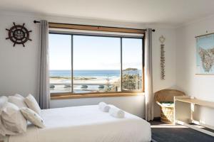 a bedroom with a large window with a view of the ocean at Drift - Watch the world go by in Scamander
