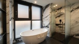 a bath tub in a bathroom with a window at HOTEL THE MAY Jongno in Seoul +70 photos