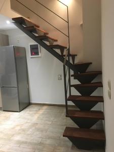 a spiral staircase in a room with a refrigerator at Villa Kazani by Karda Suites in Chios