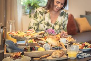 a woman standing at a table with a tray of food at das Ebner in Stubenberg
