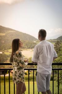 a man and a woman standing on a balcony with a view at das Ebner in Stubenberg