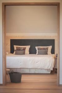 a bedroom with a large bed with white sheets and pillows at das Ebner in Stubenberg
