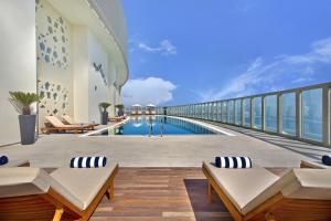a swimming pool on the balcony of a building at The Curve Hotel in Doha