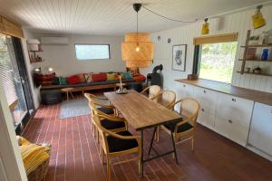 eine Küche und ein Esszimmer mit einem Holztisch und Stühlen in der Unterkunft Ferienhaus In Der Nähe Eines Schönen Sandstrandes in Gedser
