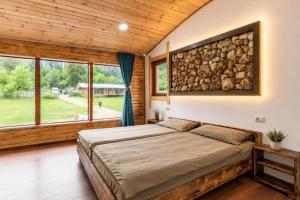a bedroom with a bed and a large window at Heshkili huts and cabins Svaneti in Keshkili