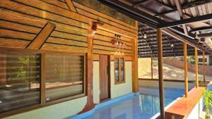 a view of a house with a pool and windows at Vayuvana Heritage Organic Farm Resort in Panamaram