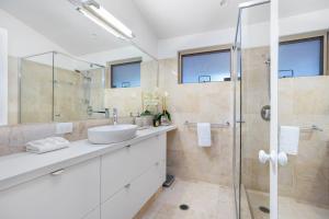 a bathroom with a sink and a glass shower at Witta Circle 24 in Noosa Heads