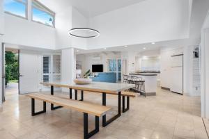 a kitchen and dining room with a table and benches at Witta Circle 24 in Noosa Heads