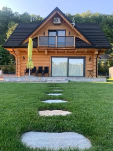 a log house with a pathway in the grass at Bałtowska Osada in Bałtów