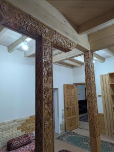 a room with a large wooden pillar and a door at Passu Didargah Resort in Pasu +9 photos