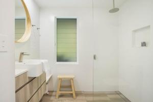 a bathroom with a sink and a stool at Townhouse 6 Sunseeker Close 26 in Noosaville +7 photos