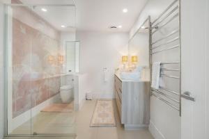 a white bathroom with a sink and a toilet at Townhouse 6 Sunseeker Close 26 in Noosaville