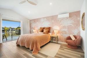 a bedroom with a bed and a chair at Townhouse 6 Sunseeker Close 26 in Noosaville