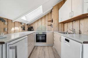 a kitchen with white cabinets and a sink at Mtb Beach Peace Holiday By The Dunes in Fjerritslev