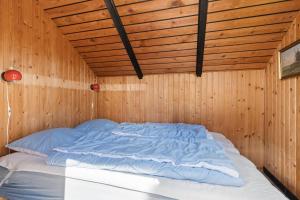 a bed in a room with a wooden ceiling at Mtb Beach Peace Holiday By The Dunes in Fjerritslev