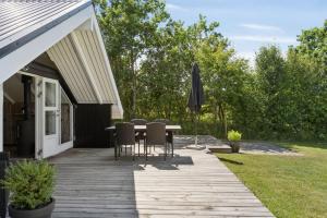 a patio with a table and chairs and an umbrella at Mtb Beach Peace Holiday By The Dunes in Fjerritslev +10 photos