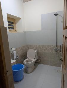 a bathroom with a toilet and a blue bucket at Passu Didargah Resort in Pasu