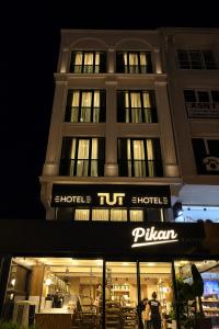 a building with a lit up sign in front of it at Tut Hotel in Antalya