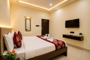 a bedroom with a large bed and a television at Hotel Vibe Blu Near JHV Mall in Varanasi