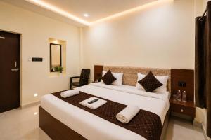 a bedroom with a large bed with towels on it at Hotel Vibe Blu Near JHV Mall in Varanasi