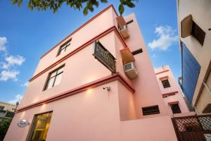 a pink building with a sign on it at Hotel Vibe Blu Near JHV Mall in Varanasi
